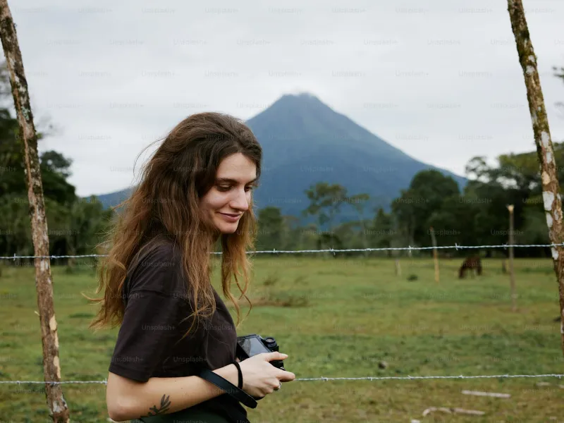 Female traveler relaxed and smiling in front of Arenal Volcano Costa Rica
